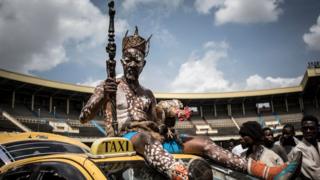A Congolese wrestler's fetisheur sits on top of a car as he arrives to the Stade De Martyrs for a sports exhibition day in Kinshasa, DR Congo - Tuesday 8 January 2019
