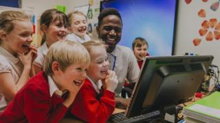 Students crowd a computer