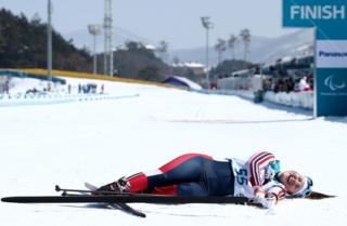 Vilde Nilsen of Norway lies on the ground whilst smiling after crossing the finishing line