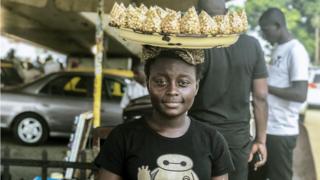 Street seller with a peanut tray on his head