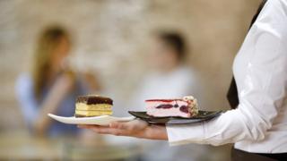 Waiter serving dessert