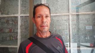Mendieta Murillo stands in front of a shop