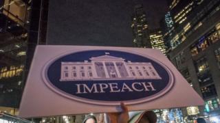 Sign reads 'IMPEACH' at the RISE and RESIST protest held at the TRUMP INTERNATIONAL TOWER on December 21, 2017 in New York City