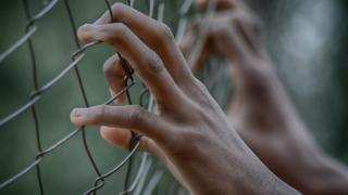 Hand dey hold prison fence