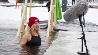 Una mujer dando un discurso en el agua helada.
