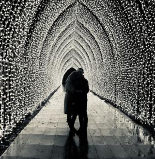 Two people standing in a tunnel of lights