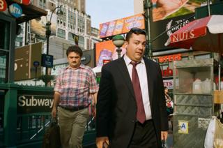 Two men in the street next to a subway station