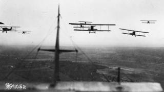 View from the back of a World War One plane, of planes flying in formation.