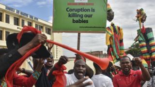 Protestors dey hold placard wey dey read 'Corruption dey kill wanna babies' for 'Fabewoso - Bring am on' demonstration under