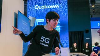 An employee talks about 5G at Qualcomm's booth at Mobile World Congress 2019 in Barcelona