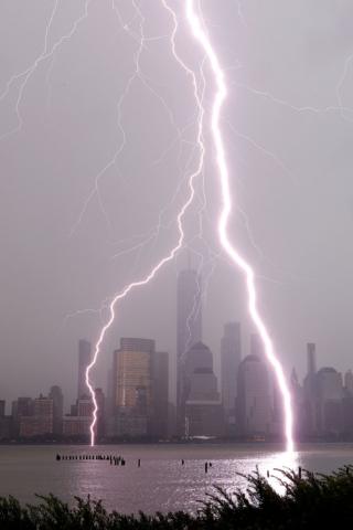 in_pictures Lightning bolts hit a river with a city skyline behind