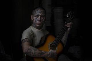 An inmate and former La 18 gang member plays the guitar at the Penal San Francisco Gótera, El Salvador. November 8, 2018.