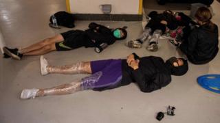 Protesters sleep on the floor of a parking lot inside the Hong Kong Polytechnic University