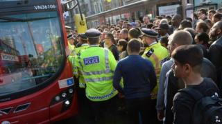 Полиция помогает огромным толпам людей сесть в автобусы