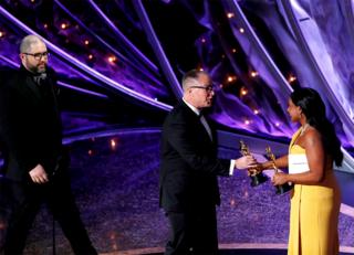 Mindy Kaling presents an Oscar to Josh Cooley and Mark Nielsen