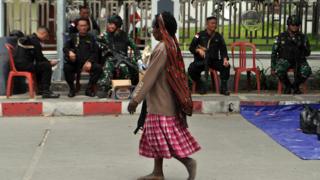 Warga melintasi penjagaan prajurit TNI dan Polri di Wamena,Papua, Sabtu (30/11).