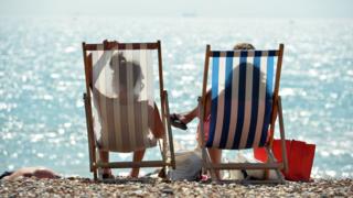 Two people sit in deckchairs