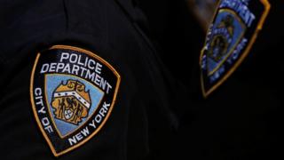 A New York Police Department badge on an officer's uniform