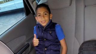 Brayan sonriendo dentro de su carro familiar