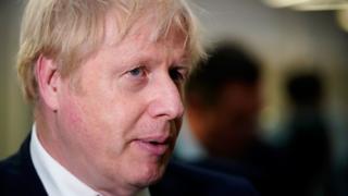 Prime Minister Boris Johnson speaks to staff and students during a visit to Bolton University chancellor"s building after a huge blaze damaged a block of student accommodation flats in Bolton on Friday evening