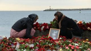 Wasu da ke mika alhinin su ga mamatan wajen sanya furanye