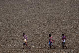 Locals pass by the dry Puzhal reservoir on the outskirts of Chennai, India on June 29, 2019.