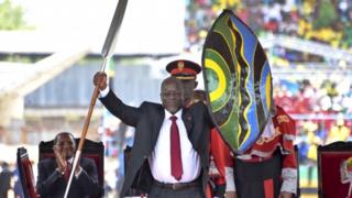 Новый президент Танзании Джон Помбе Магуфули держит церемониальное копье и щит, чтобы обозначить начало своего президентства, вскоре после принятия присяги на церемонии инаугурации на стадионе Ухуру в Дар-эс-Саламе, Танзания, четверг, 5 ноября 2015 г.