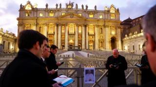 Priests pray outside of St Peter's Basilica