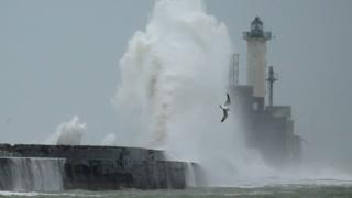 Waves crash against a lighthouse in Boulogne-sur-Mer, France