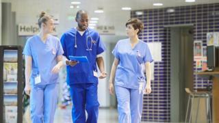 Three doctors walking down corridor