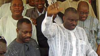 Le Chef James Ibori (au premier plan en blanc) lève sa main pour remercier ses sympathisants à sa sortie du palais de justice d'Asaba le 17 décembre 2009