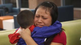 Una mujer abraza emocionada a su hijo tras la reunificación