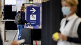 A woman enters the coronavirus test area at Amsterdam Schiphol Airport