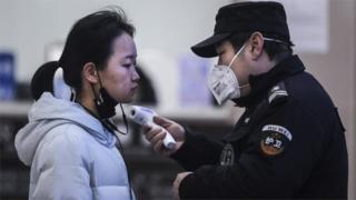 중국 우한에서 보안요원이 보행자의 체온을 측정하고 있다