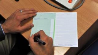 A GP writing a prescription
