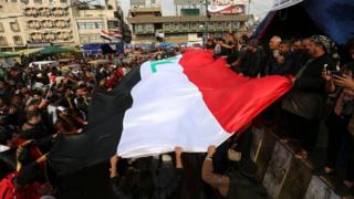 المتظاهرون يرفعون العلم العراقي في ساحة التحرير