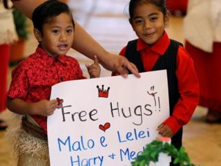 two children holding up a sign saying "free hugs"