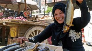 Una mujer sosteniendo un pescado