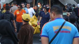Petugas mengangkut jasad dari salah seorang korban serangan di Gereja Pantekosta, Surabaya, Minggu (13/05).