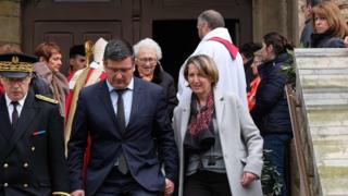 Mayor of Trebes Eric Menassi (centre) and his wife Director of Super U supermarket Samia Menassi (right) leave the remembrance service at the Saint Etienne Church in Trebes, southwest France.
