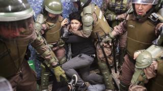 Chilean police detain a protester at the Los Heroes metro station in the middle of a demonstration in Santiago