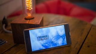 A smartphone with the Orange is the New Black logo