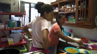 Cousuelo Villega Mendoza, 44, and her daughter cook the Colombian stew Mondongo to serve at a restaurant they run out of the home Villega built