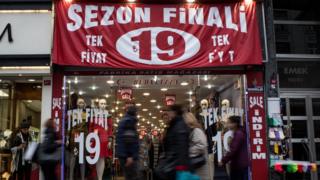 Türkiye'de indirime giren bir mağaza ve sokaktan geçenler.