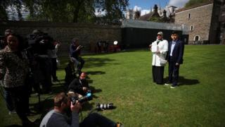 Fatima Boudchar, wife of Libyan politician Hakim Belhadj, stands with their son Abderrahim, as she holds a letter of apology from Prime Minister Theresa May outside the Houses of Parliament in Westminster