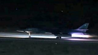 A B-1 bomber taking off from a runway in the dark
