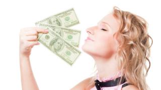 Una mujer disfrutando del aroma del dinero