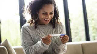 woman holding pregnancy test
