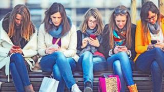 مجموعة من الفتيات يتصفحت هواتفهن المحمولة