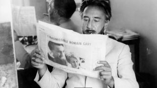 Romain Gary leyendo un periódico.